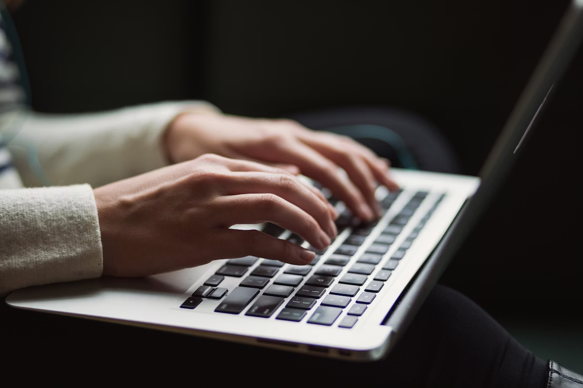 Person typing on a laptop while managing admin rights and cybersecurity settings